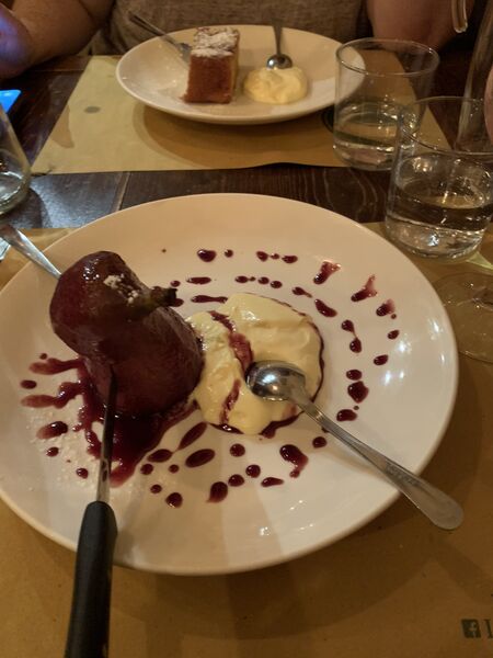 apple cake in the background; a pear braised in red wine in the foreground